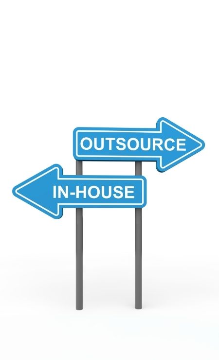 Signpost with arrows indicating "Outsource" and "In-House" options, representing IT outsourcing decisions for businesses.