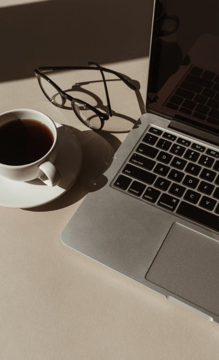 Laptop, coffee cup, and glasses illustrating secure and efficient remote work.