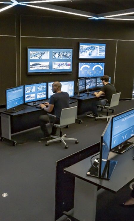 Security Operation Center (SOC) with analysts monitoring multiple screens for cybersecurity threats and data analysis.