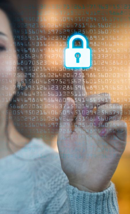Woman interacting with a digital interface displaying a padlock symbol and binary code, emphasizing cybersecurity measures and data protection.